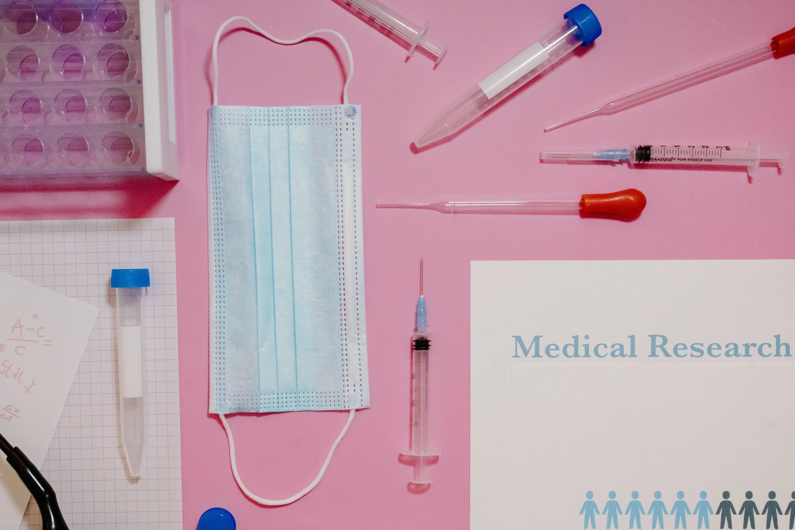 Medical research equipment including laboratory supplies, face mask, syringes, and specimen collection tools used in clinical trials.
